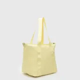 Bolso tipo tote color amarillo, de diseño acolchado con costuras horizontales. Cuenta con doble asa de mano y una correa larga ajustable y extraíble. Incluye un pequeño detalle de etiqueta lateral.