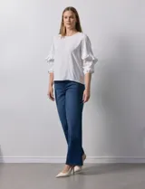 Blusa de gasa estampada con flores azules y violetas sobre fondo blanco, de manga 3/4 con volados.