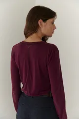 Remera manga larga color borgoña con cuello en V y costuras decorativas verticales.