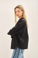 Saco corto de lino con corte oversize y mangas amplias. Presenta un diseño de doble abotonadura frontal y forro interior de lino.