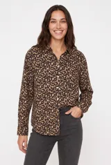 Camisa de manga larga con estampado animal print tipo leopardo, cuello camisero, cierre frontal con botones y bolsillo ojal en el pecho.