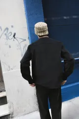 Sobrecamisa negra de corte clásico con cuello camisero en contraste color marrón a cuadros. Presenta cierre frontal con botones, dos bolsillos frontales tipo parche y una etiqueta decorativa con el logo de la marca en el pecho.