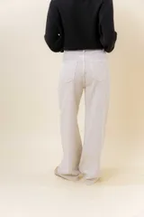 Jean wide leg de tiro alto con costura frontal decorativa, bolsillos delanteros con remaches y bolsillos traseros amplios. Presenta un interior afelpado para mayor abrigo.