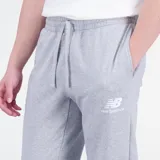 Pantalon de jogging New Balance, confeccionado en felpa francesa color gris melange. Presenta un corte deportivo con cintura y puños acanalados, bolsillos laterales y un bolsillo trasero. Incluye el logo de la marca estampado en la pierna izquierda.