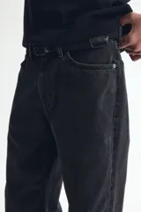 Jean de cinco bolsillos en denim de algodón rígido, con modelo de cintura clásica, cierre de botones y piernas rectas de corte relajado.