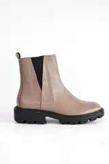 Bota Chelsea de cuero color marrón chocolate con elástico lateral negro, suela track de goma negra y tirador trasero.