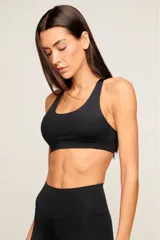 Top deportivo blanco de poliamida con diseño de espalda nadador, breteles medios y banda elástica inferior para mayor soporte. Cuenta con forro interno y entrada para copas removibles.