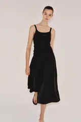 Falda midi de tiro medio color negro, con cintura elástica, bolsillos laterales ocultos y bajo con acabado en línea evasé.