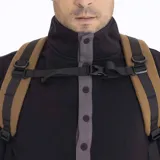 Mochila de 25 litros marca Merrell, modelo Trout Basic, en color mostaza. Confeccionada en poliéster Oxford con recubrimiento de poliuretano, presenta un compartimento principal con cierre, bolsillos laterales de malla con correas de compresión y una cinta frontal con bucles.