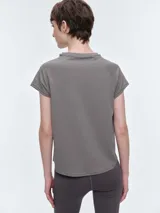 Remera deportiva de manga corta con cuello redondo y costuras tipo raglán. Confeccionada en tejido técnico elástico, presenta un diseño liso y entallado, ideal para actividades físicas.