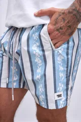 Short de baño celeste con rayas verticales blancas y estampado de flores blancas y azules.