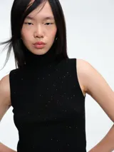 Top sin mangas al cuerpo confeccionado en tejido de viscosa con micro lentejuelas brillantes. Presenta cuello alto y diseño elástico, ideal para diversas ocasiones.