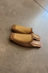 Mules color beige con capellada de cuero y detalle de costuras en hilo marrón.