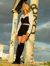 Minifalda negra drapeada con tiras finas en los laterales.