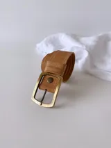 Cinto de cuero color camel con forro de cuero y hebilla rectangular metálica. Presenta un broche suizo para intercambiar la hebilla.