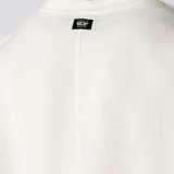 Remera oversize de lino entramado color blanco off-white, con cuello redondo, mangas cortas de hombro caído y etiqueta aplicada en el borde inferior.
