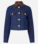 Campera de jean azul con cuello inglés de poliuretano color marrón. Cierre frontal con botones metálicos. Bolsillos de parche en el pecho con detalle de ribete de poliuretano marrón.