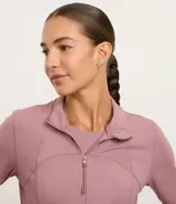 Campera deportiva de microfibra con cierre frontal, cuello alto y diseño con recortes anatómicos. Cuenta con bolsillos laterales y mangas largas.