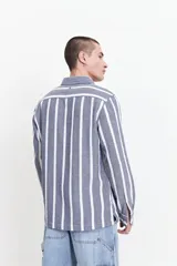 Camisa de manga larga Mistral con diseño de rayas verticales en tonos beige y gris. Presenta una textura tipo waffle, cuello clásico y cierre frontal con botones.