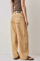 Jeans de corte barrel en color tostado, con diseño de perneras curvadas y costuras pespunteadas.