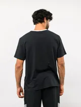 Remera de corte clásico color blanco, con cuello redondo en color rosado y logo de la marca bordado en el pecho en el mismo tono.