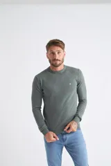 Sweater de algodón en butoné color verde, con cuello redondo, puños y dobladillo acanalados, y logo bordado en el pecho.