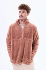 Buzo de sherpa de textura suave y cálida, con cuello alto y cierre frontal parcial. Presenta un diseño de manga larga y corte holgado.