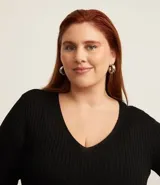 Blusa negra de punto liviano con textura acanalada, escote en pico y mangas largas.