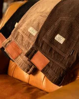 Pantalon de pana negra con textura acanalada, corte recto y diseño de cinco bolsillos.
