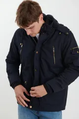 Campera de abrigo estilo parka, color verde militar, con capucha desmontable, cierre frontal con botones y múltiples bolsillos funcionales en pecho, cintura y manga.