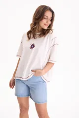 Remera blanca de algodón, corte semi boxy con mangas cortas, costuras en contraste color bordó y detalle bordado de sol en el pecho.