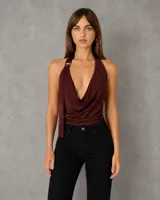 Top halter de satén color borgoña con escote drapeado, espalda descubierta y detalle de argolla metálica en el hombro.