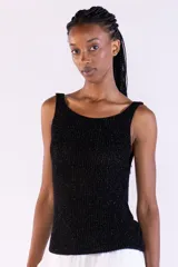 Musculosa de punto canalé color negro, tejida con hilos metálicos de lurex que aportan un brillo sutil, con escote bote y tirantes anchos.