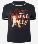 Remera negra de algodón con cuello redondo, manga corta y ribetes blancos contrastantes en cuello y mangas. Presenta una estampa fotográfica frontal de Jennie con tipografía en tonos rojos.