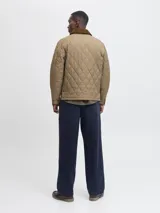 Campera acolchada de diseño matelasse en color tostado, con cuello camisero en pana marrón, cierre frontal con broches a presión, bolsillos frontales con solapa y puños ajustables.