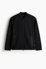Campera bomber deportiva en tejido funcional DryMove color negro, con cuello elevado corto, cierre frontal bidireccional, mangas raglán y bolsillos delanteros con cierre y costuras selladas.