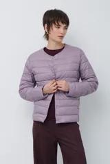 Campera acolchada tipo puffer en color beige, con diseño sin cuello y cierre frontal con botones a presión.