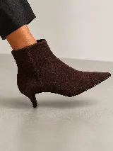 Bota corta de cuero con punta fina y taco fino de 5 cm, diseño minimalista y elegante.