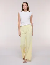 Pantalón sastrero blanco de tiro alto, corte wide leg y pierna ancha con caída fluida. Cuenta con cintura ancha lisa, cierre frontal oculto y bolsillos laterales.