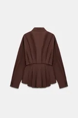Camisa de cuello solapa y manga larga, confeccionada en popelín. Presenta un diseño con cintura entallada mediante pliegues y cierre frontal con botones ocultos por solapa.