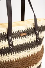 Bolso tipo tote de diseño trenzado con patrón de rayas en tonos marrones y beige, doble asa larga de material sintético oscuro y placa metálica con logo.