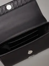 Cartera de hombro Calvin Klein negra con solapa acolchada con patrón de rombos. Posee correa de cadena metálica y logo metálico grabado en la parte frontal.