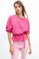 Blusa color salmón de manga tres cuartos con leve volumen, largo hasta la cadera y cinto extraíble en la espalda.