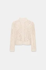 Blazer de encaje con cuello redondo, manga larga con puños y cierre frontal con botones. Presenta un diseño estructurado con bajo recto.