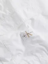 Pantalón cargo blanco de algodón regenerativo, con cintura elástica y tobillos ajustables con cordones. Presenta bolsillos cargo laterales y un parche de goma con el logo de Calvin Klein Jeans.