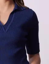 Buzo azul de tejido acanalado, con cuello solapa y escote en V en tejido calado.