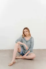 Blusa celeste de gasa con escote en V, mangas tres cuartos y diseño en capas con volados.