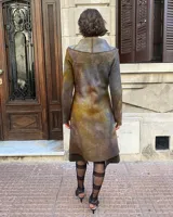 Tapado rojo de lana merino afieltrada, corte recto con lazos para ajustar en la cintura y cuello alto con posibilidad de cruzar los lazos alrededor. Tiene bolsillos laterales.