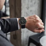Reloj analógico Mini Focus con movimiento de cuarzo japonés, caja de aleación de zinc y correa de cuero negra. Presenta una esfera negra minimalista con subesferas y ventana de fecha.