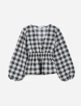 Blusa negra y blanca con estampado de cuadros escoceses, escote en V cruzado, frunce elástico en la cintura y mangas largas abullonadas.